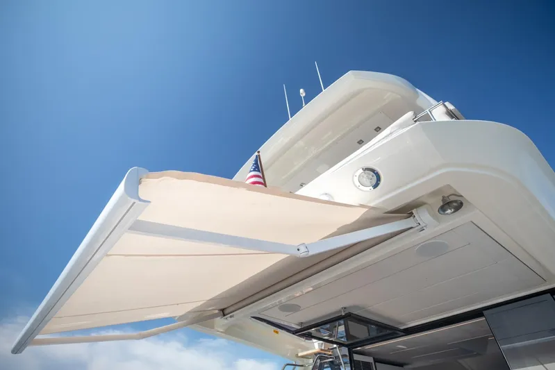  Yacht Photos Pics 2020 Prestige 590 Flybridge Cruiser with extended awning under clear blue sky.