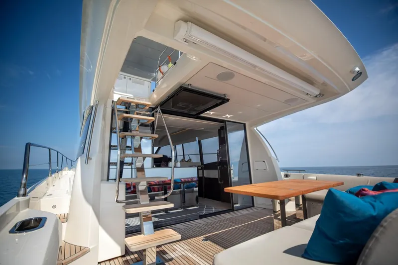  Yacht Photos Pics Prestige 590 Flybridge Cruiser 2020, luxurious deck view with seating and ocean backdrop.