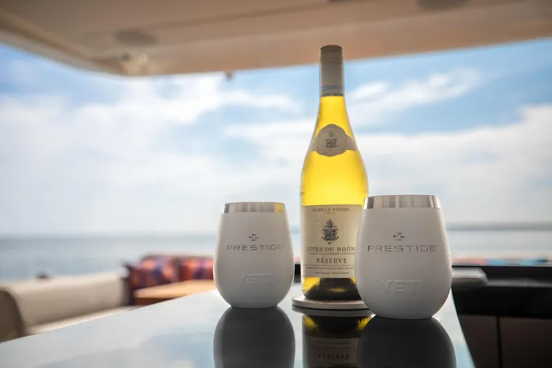  Yacht Photos Pics Wine and Prestige cups on 2020 Prestige 590 Flybridge Cruiser, ocean view.