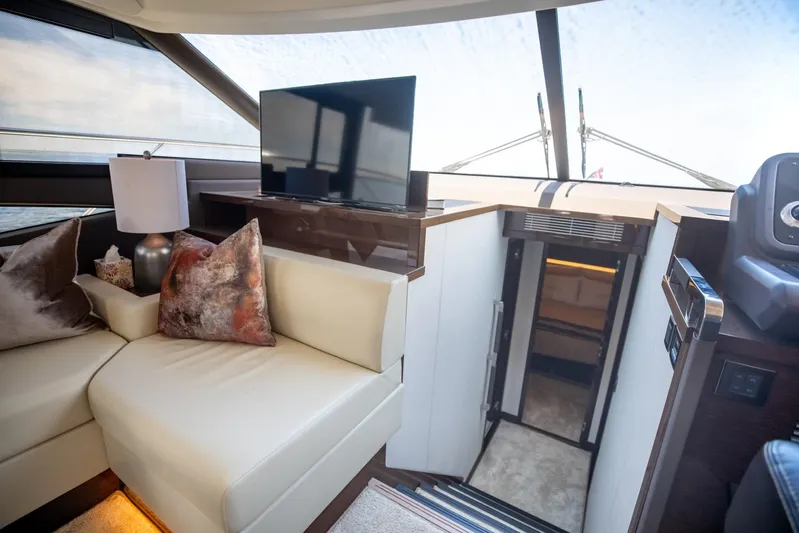  Yacht Photos Pics Luxurious interior of 2020 Prestige 590 Flybridge Cruiser with modern seating and TV.