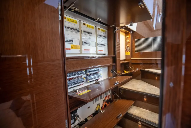  Yacht Photos Pics Electrical panel inside 2020 Prestige 590 Flybridge Cruiser, featuring wooden cabinetry and circuit breakers.