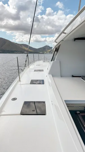 Yacht Photos Pics 2023 Fountaine Pajot Tanna 47 yacht deck with scenic ocean and mountain view.