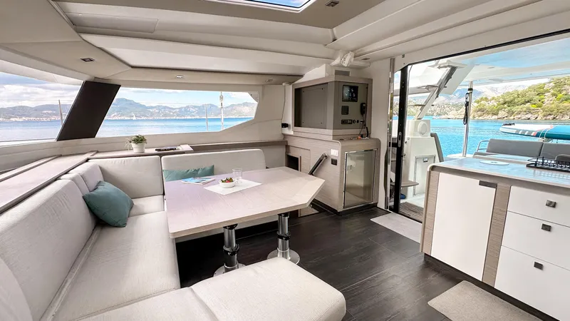  Yacht Photos Pics Luxurious interior of 2023 Fountaine Pajot Tanna 47 catamaran with modern furnishings and scenic views.