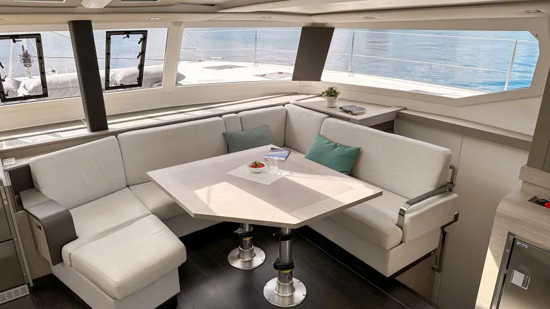  Yacht Photos Pics Luxurious interior of 2023 Fountaine Pajot Tanna 47 catamaran with elegant seating and dining area.