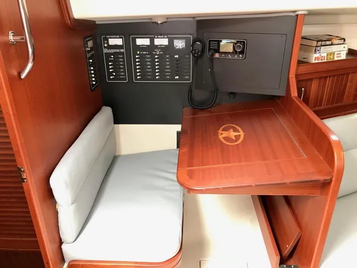 Salacia Yacht Photos Pics Navigation station in 2016 Blue Jacket 40 sailboat with control panels and cushioned seat.