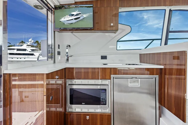 Bradventures Yacht Photos Pics Modern kitchen interior of 2023 Cruisers Yachts 42 Cantius with wood finish and appliances.