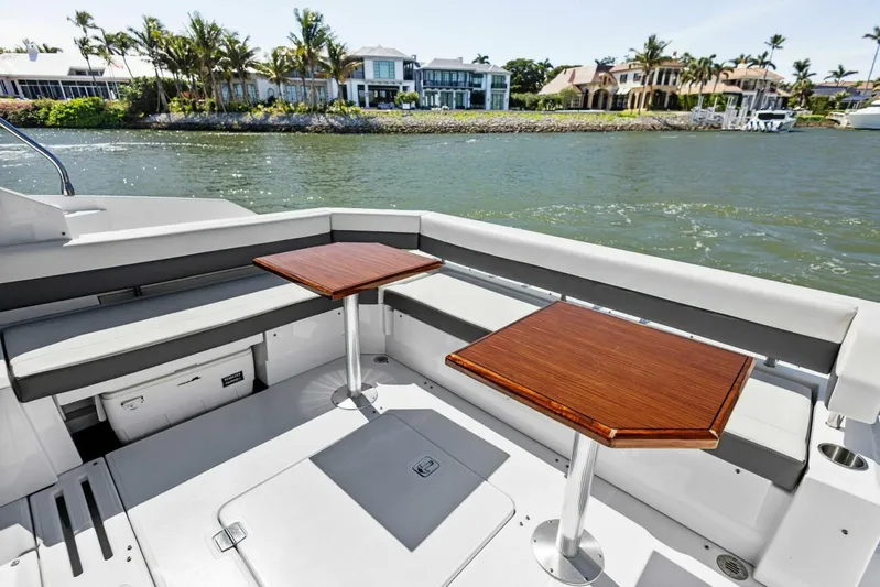 Bradventures Yacht Photos Pics 2023 Cruisers Yachts 42 Cantius deck with seating and tables, overlooking waterfront homes.