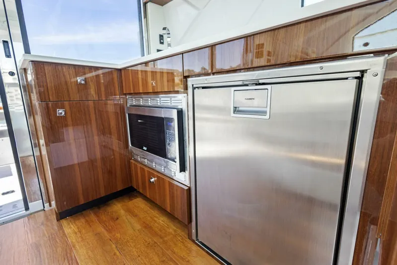 Bradventures Yacht Photos Pics 2023 Cruisers Yachts 42 Cantius galley with wood cabinetry and stainless steel appliances.