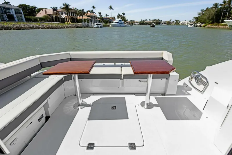 Bradventures Yacht Photos Pics 2023 Cruisers Yachts 42 Cantius deck with seating and tables, overlooking serene waterfront.