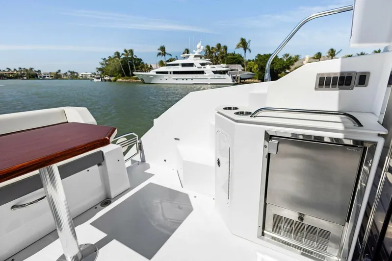 Bradventures Yacht Photos Pics 2023 Cruisers Yachts 42 Cantius deck with seating and mini fridge, overlooking serene waters.