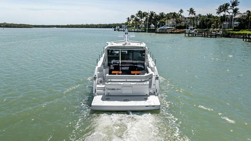 Bradventures Yacht Photos Pics 2023 Cruisers Yachts 42 Cantius cruising on a serene waterway, surrounded by lush greenery.