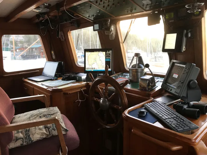 Orina Yacht Photos Pics Pilothouse interior of 1971 Southern Marine MALAHIDE, featuring navigation equipment and wooden steering wheel.