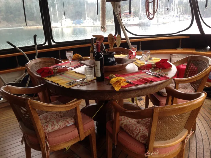 Orina Yacht Photos Pics Dining area on 1971 Southern Marine MALAHIDE Pilothouse LRC, elegantly set with wine and tableware.