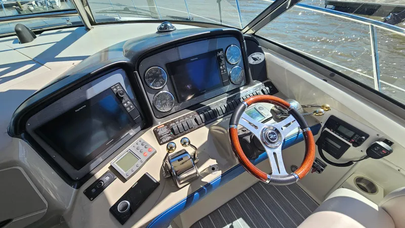  Yacht Photos Pics Helm of 2005 Sea Ray 390 Sundancer with modern navigation equipment and wooden steering wheel.