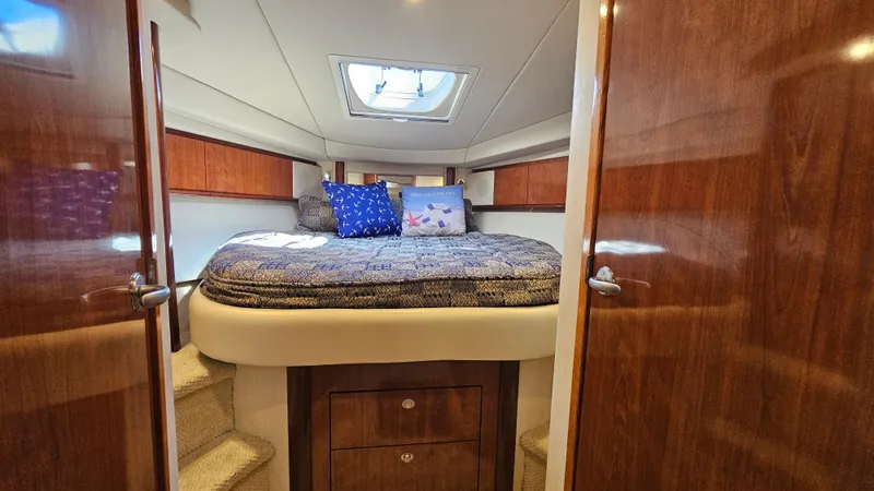  Yacht Photos Pics Luxurious cabin interior of 2005 Sea Ray 390 Sundancer with cozy bedding and wooden accents.