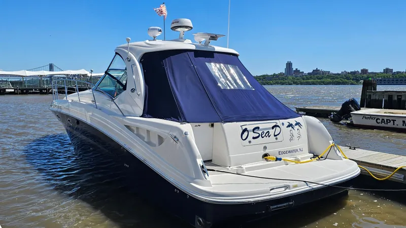 Yacht Photos Pics 2005 Sea Ray 390 Sundancer yacht docked, featuring sleek design and blue canopy.