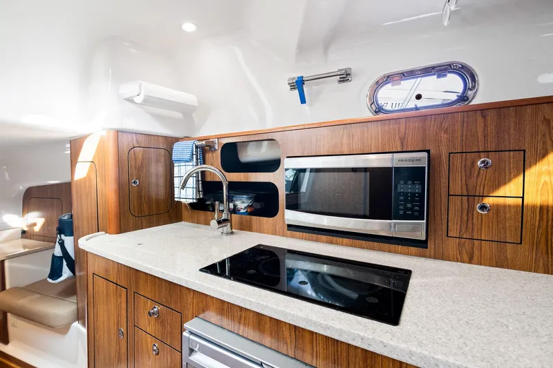 Let&rsquo;s Go II Yacht Photos Pics 2013 Pursuit OS 345 Offshore yacht interior kitchen with wood cabinetry and modern appliances.