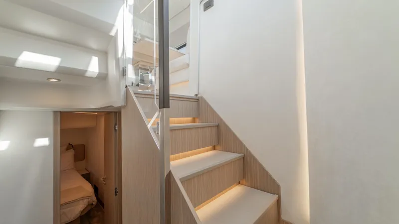  Yacht Photos Pics Modern interior of Prestige F4.9 yacht, 2025 model, featuring sleek staircase and cozy cabin.