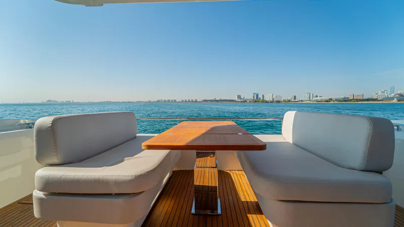  Yacht Photos Pics Luxury seating area on Prestige F4.9 yacht, 2025 model, overlooking serene ocean and city skyline.