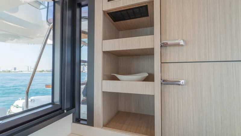  Yacht Photos Pics Modern yacht interior with wooden cabinetry, Prestige F4.9, 2025 model, featuring open shelving and ocean view.