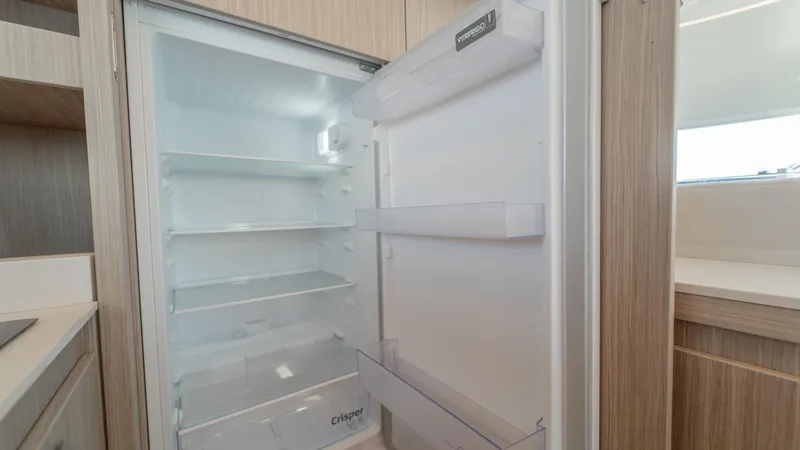  Yacht Photos Pics Open Prestige F4.9 refrigerator, 2025 model, with empty shelves and modern design.
