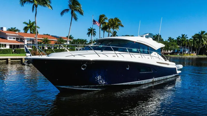 Happy Daze IV Yacht Photos Pics 2017 Tiara Yachts 53 Coupe on water, surrounded by palm trees and clear blue sky.