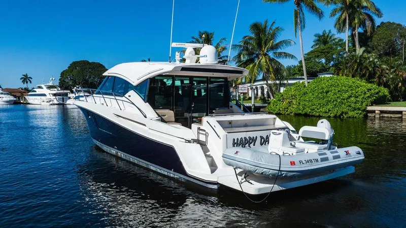 Happy Daze IV Yacht Photos Pics 2017 Tiara Yachts 53 Coupe on a sunny waterway with palm trees.