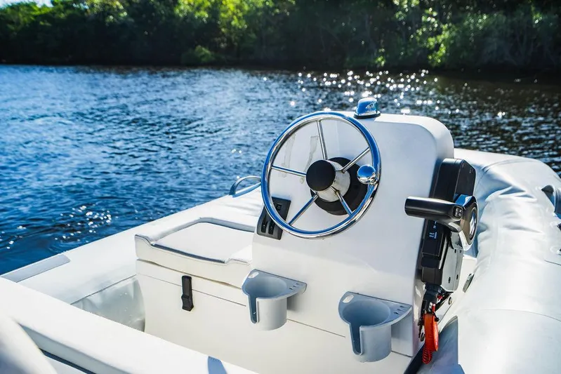 Happy Daze IV Yacht Photos Pics Steering console of a 2017 Tiara Yachts 53 Coupe on a sunny day by the water.