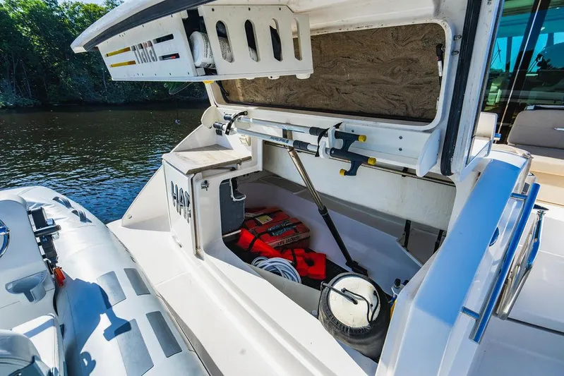 Happy Daze IV Yacht Photos Pics 2017 Tiara Yachts 53 Coupe storage compartment with life jackets and equipment by the water.