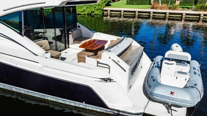Happy Daze IV Yacht Photos Pics 2017 Tiara Yachts 53 Coupe with tender, docked on calm water.