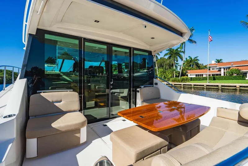 Happy Daze IV Yacht Photos Pics 2017 Tiara Yachts 53 Coupe with elegant outdoor seating and polished wooden table.