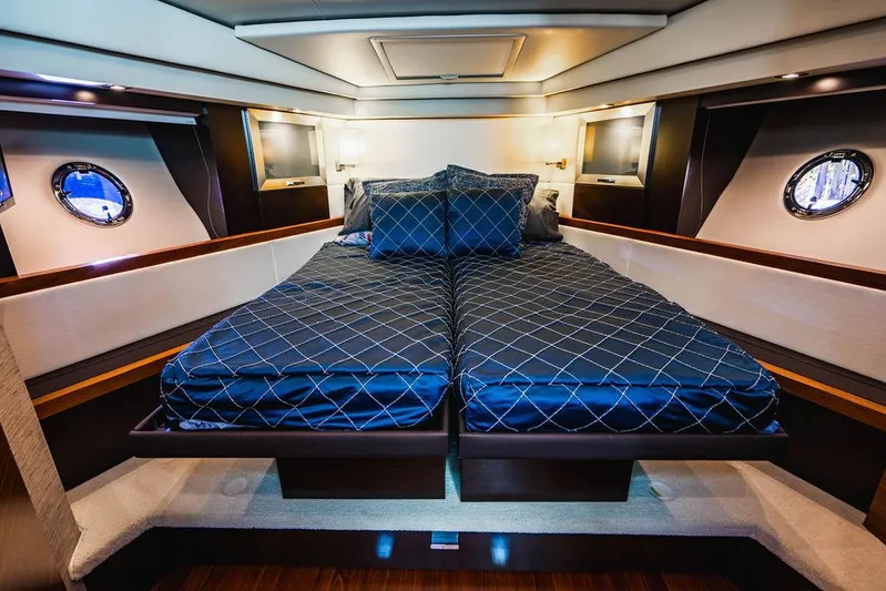 Happy Daze IV Yacht Photos Pics Luxurious bedroom interior of 2017 Tiara Yachts 53 Coupe with elegant bedding and porthole windows.