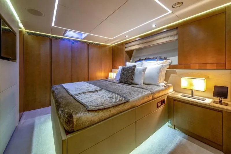  Yacht Photos Pics Luxurious bedroom interior on a 2013 Pershing 108 yacht, featuring elegant wood paneling and ambient lighting.