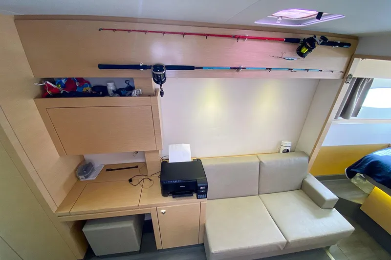  Yacht Photos Pics Interior of 2014 Fountaine Pajot Helia 44 yacht with sofa, desk, and fishing rods.