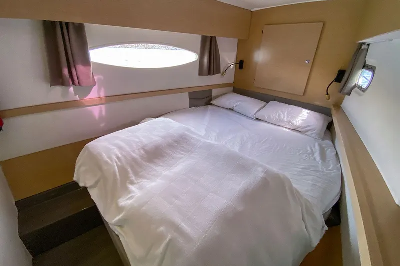  Yacht Photos Pics Cozy bedroom in 2014 Fountaine Pajot Helia 44 catamaran with double bed and porthole window.