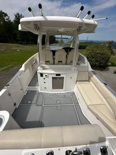 Yacht Photos Pics 2019 Regal 33 SAV boat interior with seating and helm, docked outdoors.