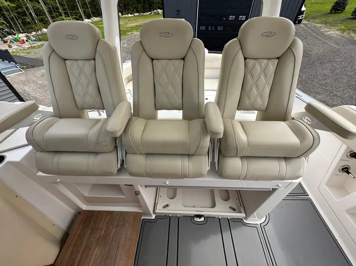  Yacht Photos Pics Luxurious seating on a 2019 Regal 33 SAV boat, featuring three plush, beige captain's chairs.