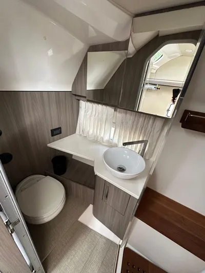 Yacht Photos Pics 2019 Regal 33 SAV boat bathroom with modern sink, toilet, and wood accents.