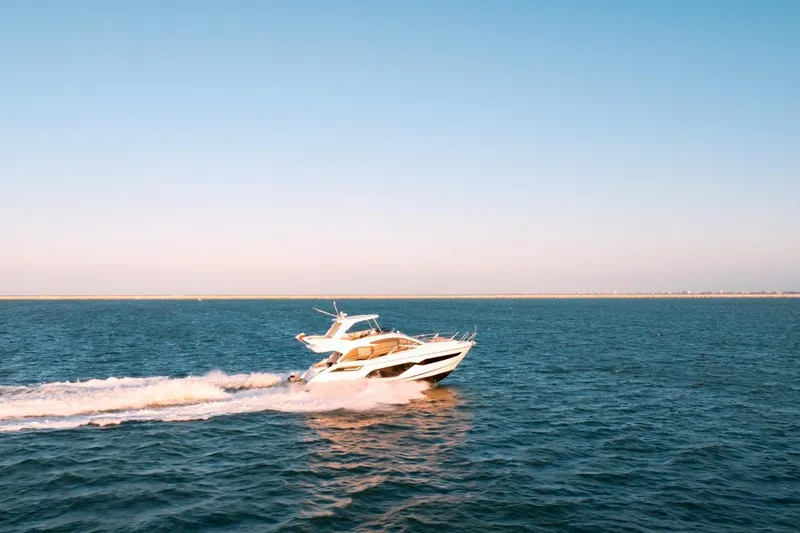  Yacht Photos Pics 2024 Sunseeker Manhattan 55 yacht cruising on open sea under clear blue sky.