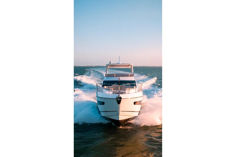  Yacht Photos Pics 2024 Sunseeker Manhattan 55 yacht cruising on open water at sunset.