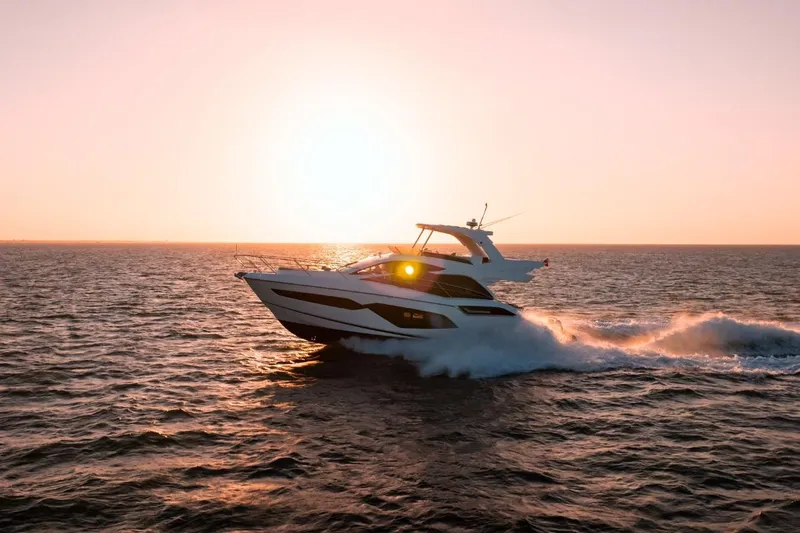  Yacht Photos Pics 2024 Sunseeker Manhattan 55 yacht cruising at sunset on open water.