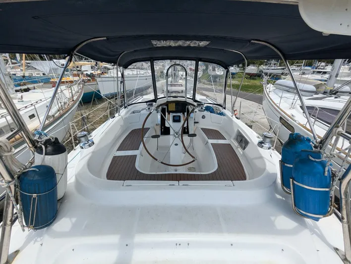 Momentum Yacht Photos Pics 2007 Hunter 45 Center Cockpit sailboat with spacious deck and steering wheel, docked at marina.