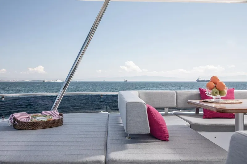  Yacht Photos Pics Luxurious Sirena 58 yacht deck with ocean view, 2021 model, featuring elegant seating and fruit centerpiece.