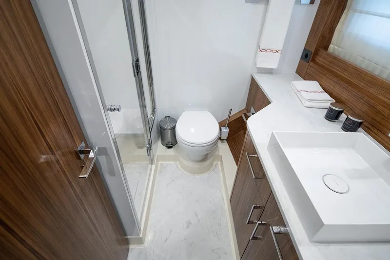  Yacht Photos Pics Modern bathroom in 2021 Sirena 58 yacht with sleek wood accents and white fixtures.
