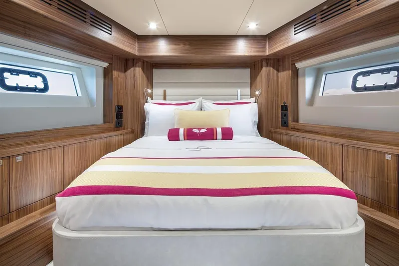  Yacht Photos Pics Luxurious cabin interior of 2021 Sirena 58 yacht with elegant wood finish and cozy bedding.