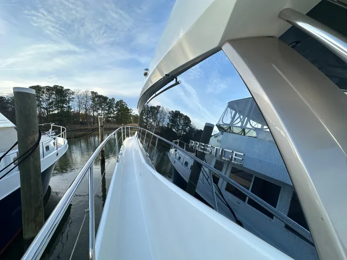  Yacht Photos Pics 2015 Prestige 500 S yacht docked, reflecting water and trees.