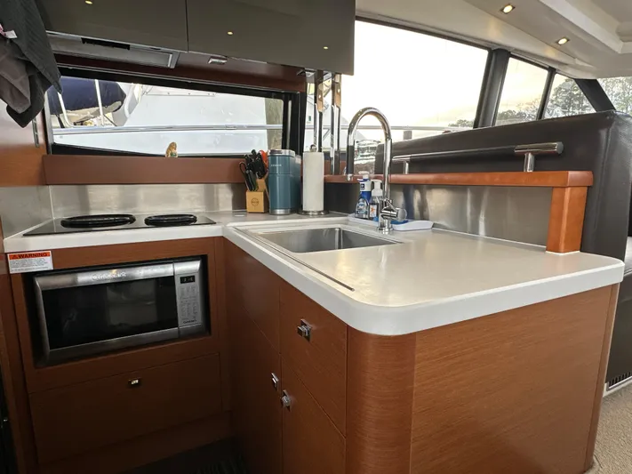  Yacht Photos Pics Modern kitchen interior of 2015 Prestige 500 S yacht with sink, stove, and microwave.