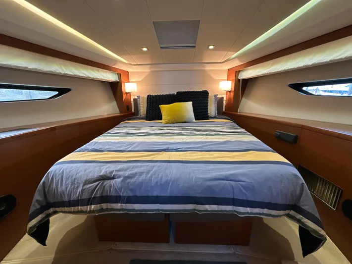  Yacht Photos Pics Luxurious bedroom interior of 2015 Prestige 500 S yacht with striped bedding and ambient lighting.