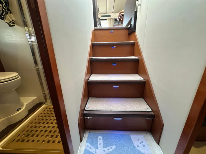  Yacht Photos Pics Staircase inside 2015 Prestige 500 S yacht, with carpeted steps and adjacent bathroom.