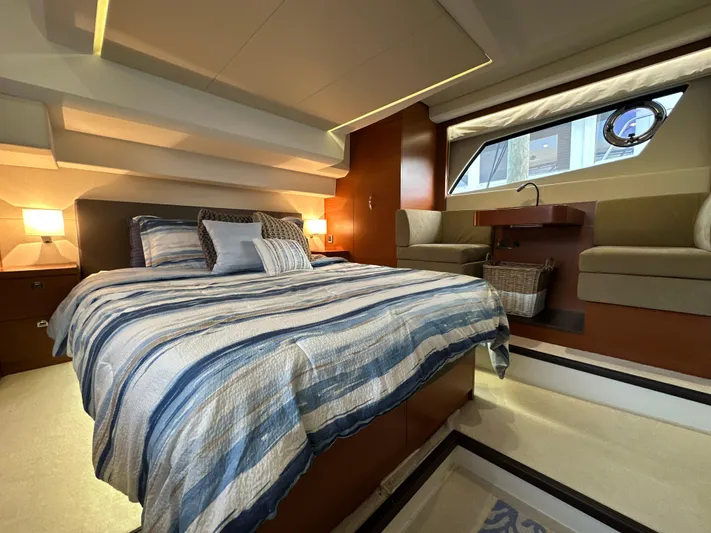  Yacht Photos Pics Luxurious bedroom interior of a 2015 Prestige 500 S yacht with striped bedding.